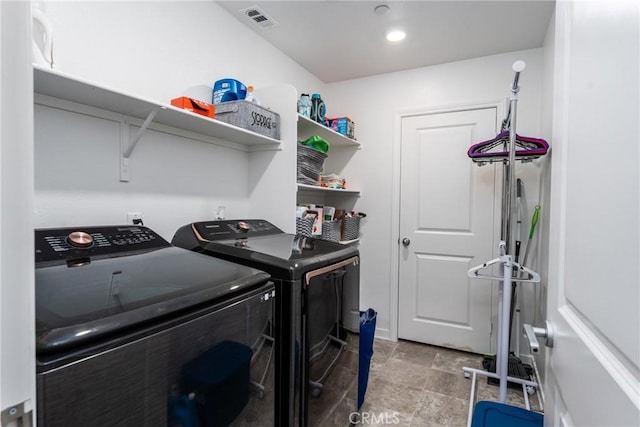 laundry area featuring stone finish floor, laundry area, washing machine and dryer, and visible vents