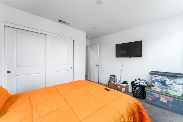 bedroom with visible vents, carpet floors, and a closet