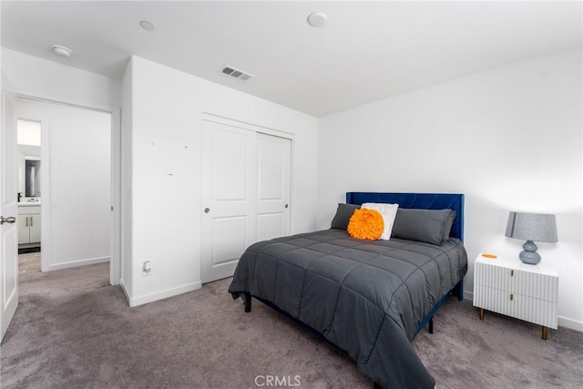 carpeted bedroom with visible vents, baseboards, and a closet