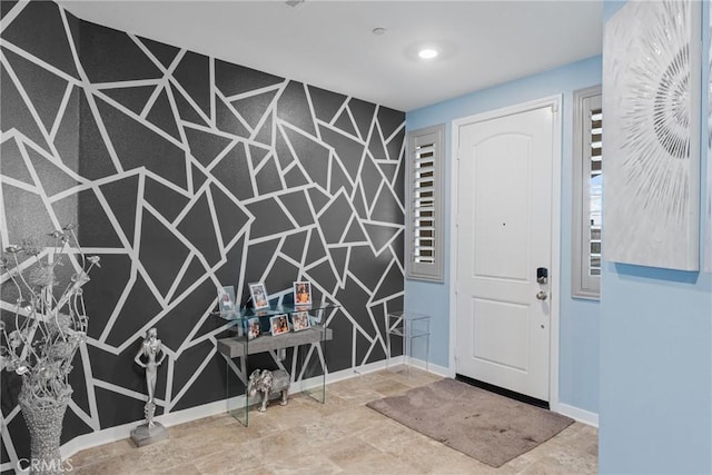 foyer featuring baseboards and stone finish flooring