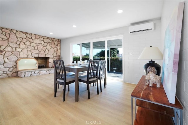 14816 Lanning Dr, Whittier, CA 90604 - dining room featuring a wall unit AC, a stone fireplace, light wood finished floors, and recessed lighting