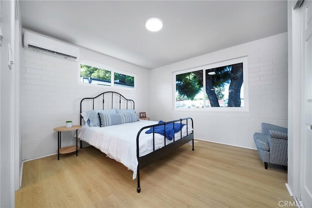 14816 Lanning Dr, Whittier, CA 90604 - bedroom featuring a wall mounted air conditioner, light wood-style flooring, and concrete block wall