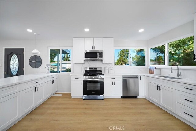 14816 Lanning Dr, Whittier, CA 90604 - kitchen featuring appliances with stainless steel finishes, a sink, white cabinetry, recessed lighting, and light stone countertops