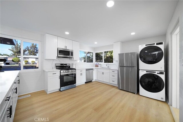 14816 Lanning Dr, Whittier, CA 90604 - kitchen with appliances with stainless steel finishes, stacked washer / drying machine, light countertops, white cabinets, and recessed lighting