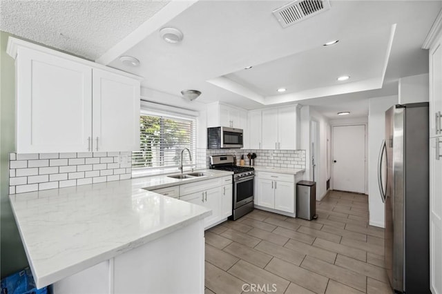 13138 Pan Am Blvd, Moreno Valley, CA 92553 - kitchen featuring appliances with stainless steel finishes, a sink, a peninsula, white cabinets, and recessed lighting