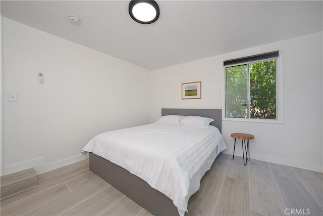 bedroom featuring light wood-type flooring and baseboards