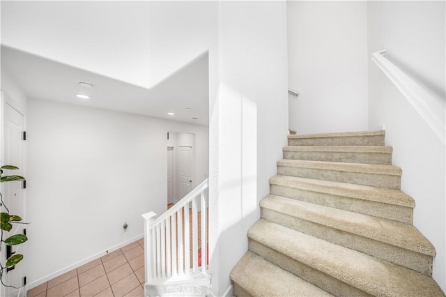 stairway featuring tile patterned floors and recessed lighting