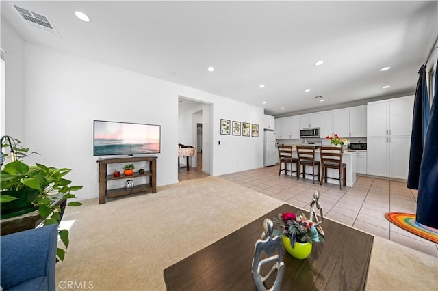 living room with visible vents, recessed lighting, and light colored carpet