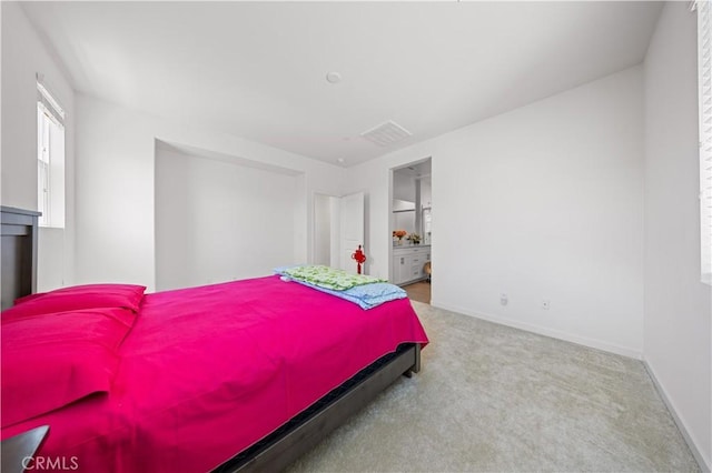 bedroom with ensuite bath, carpet, visible vents, and baseboards