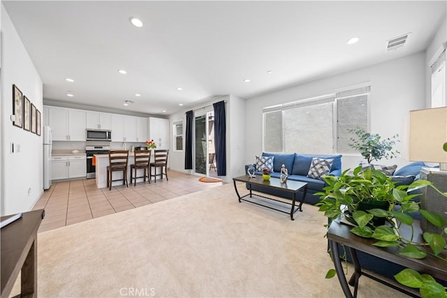 living area featuring recessed lighting, plenty of natural light, and visible vents