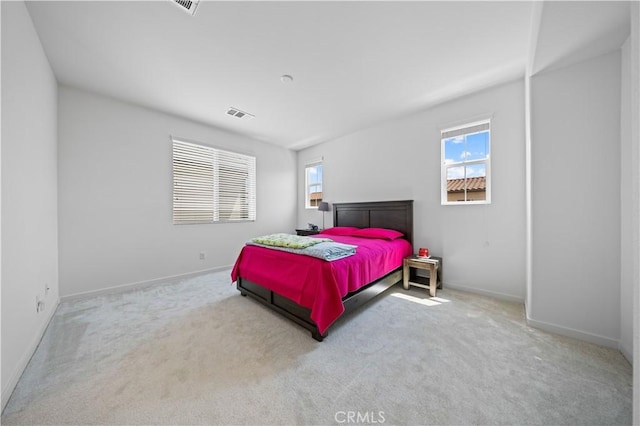 carpeted bedroom with visible vents and baseboards