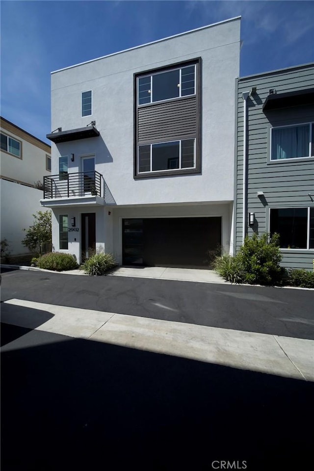 2902 Foundry Ct, Redondo Beach, CA 90278 - view of front of home with an attached garage, stucco siding, a balcony, and driveway
