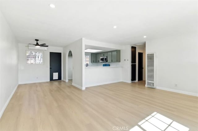 49537 Rosella Dr, Morongo Valley, CA 92256 - unfurnished living room featuring light wood finished floors, arched walkways, a ceiling fan, and a heating unit