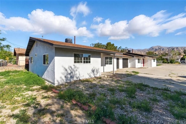 49537 Rosella Dr, Morongo Valley, CA 92256 - single story home with fence, concrete driveway, a mountain view, an attached garage, and stucco siding