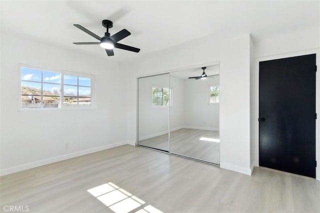 49537 Rosella Dr, Morongo Valley, CA 92256 - unfurnished bedroom with a closet, ceiling fan, wood finished floors, and baseboards