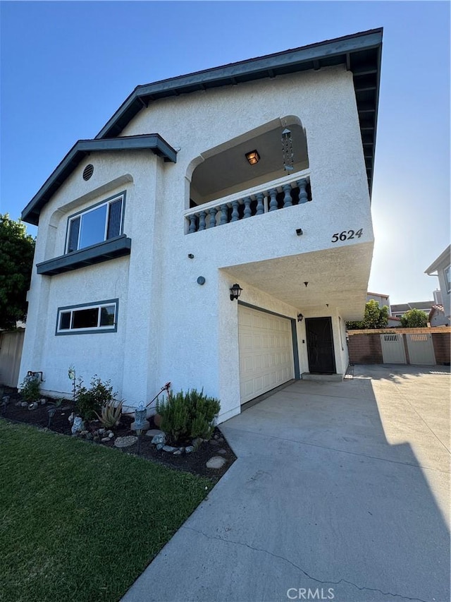 view of front of property featuring stucco siding, an attached garage, concrete driveway, and fence