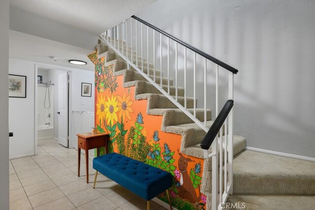 staircase with baseboards and tile patterned floors