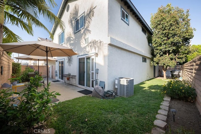 back of house featuring stucco siding, central air condition unit, and a patio