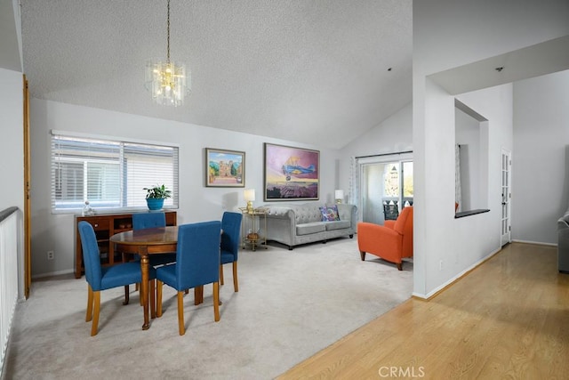 dining area featuring a chandelier, lofted ceiling, healthy amount of natural light, a textured ceiling, and baseboards