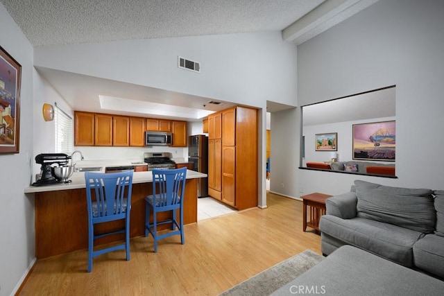 living room featuring light wood-style flooring, high vaulted ceiling, a textured ceiling, and baseboards