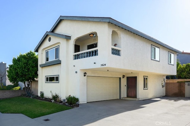 view of front of property with an attached garage, stucco siding, and concrete driveway