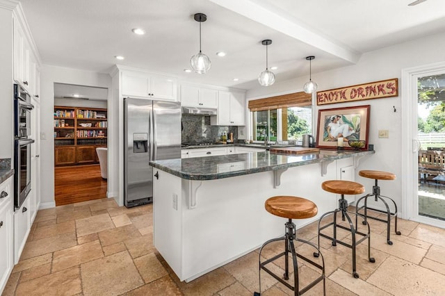 kitchen featuring stone tile floors, stainless steel appliances, white cabinets, and recessed lighting