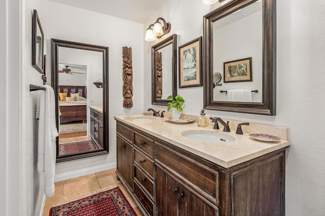 ensuite bathroom featuring connected bathroom, tile patterned floors, a sink, and double vanity