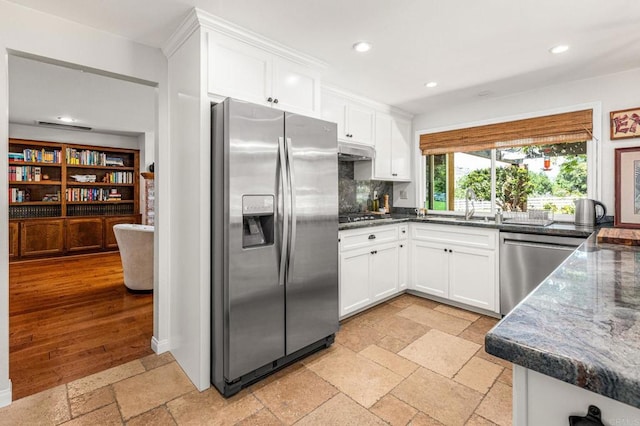 kitchen with recessed lighting, appliances with stainless steel finishes, white cabinetry, and a sink
