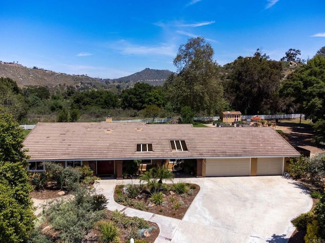 view of front of house with concrete driveway, a mountain view, and a garage
