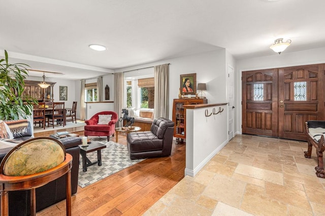 entryway with baseboards, stone tile flooring, and recessed lighting