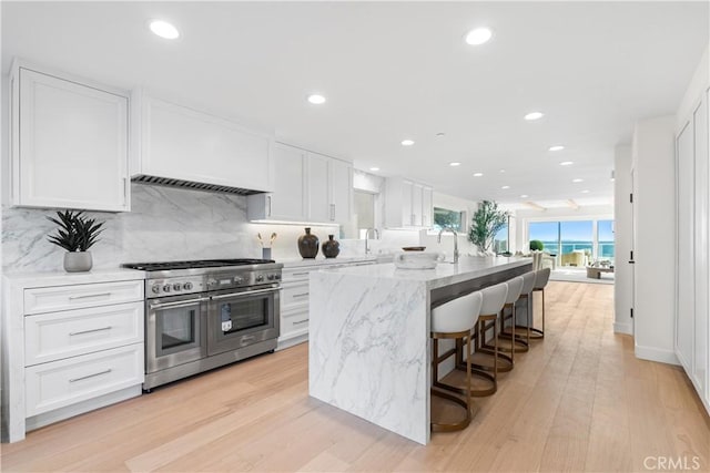 105A Surfside Ave, Surfside, CA 90743 - kitchen with range with two ovens, white cabinetry, light stone countertops, recessed lighting, and tasteful backsplash