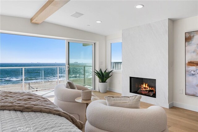 105A Surfside Ave, Surfside, CA 90743 - living area featuring a large fireplace, wood finished floors, recessed lighting, view of water and beach, and beam ceiling
