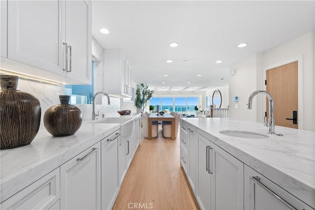 105A Surfside Ave, Surfside, CA 90743 - kitchen with recessed lighting, light wood-style flooring, light stone countertops, white cabinets, and tasteful backsplash