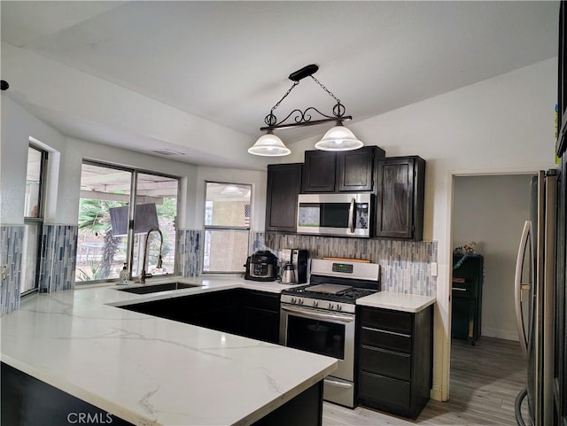 14055 Camino Del Oro, Riverside, CA 92508 - kitchen featuring stainless steel appliances, a sink, light stone counters, backsplash, and a peninsula