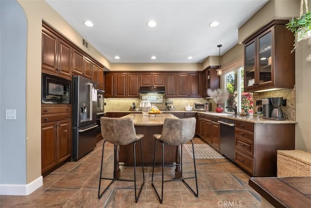 9 Healdsbury, Irvine, CA 92602 - kitchen with appliances with stainless steel finishes, light stone counters, a center island, a kitchen bar, and under cabinet range hood