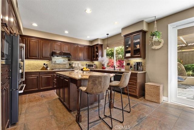 9 Healdsbury, Irvine, CA 92602 - kitchen with a kitchen breakfast bar, under cabinet range hood, tasteful backsplash, and dark brown cabinets