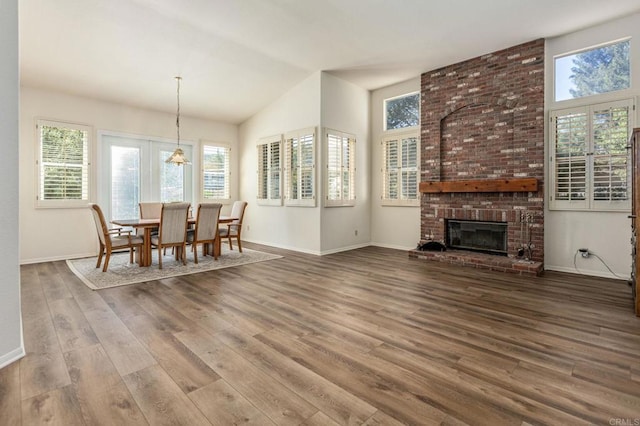 3602 Hidden Ridge Rd, Jamul, CA 91935 - dining room featuring wood finished floors, baseboards, vaulted ceiling, a brick fireplace, and a chandelier