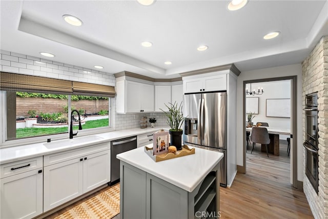 28166 Camellia Ct, Laguna Niguel, CA 92677 - kitchen featuring a sink, appliances with stainless steel finishes, a raised ceiling, light countertops, and backsplash