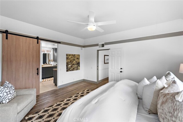 28166 Camellia Ct, Laguna Niguel, CA 92677 - bedroom featuring a barn door, light wood-style flooring, baseboards, connected bathroom, and a ceiling fan