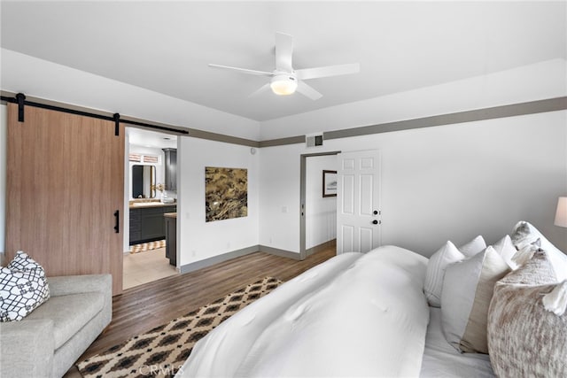28166 Camellia Ct, Laguna Niguel, CA 92677 - bedroom with a barn door, light wood-style flooring, connected bathroom, and ceiling fan