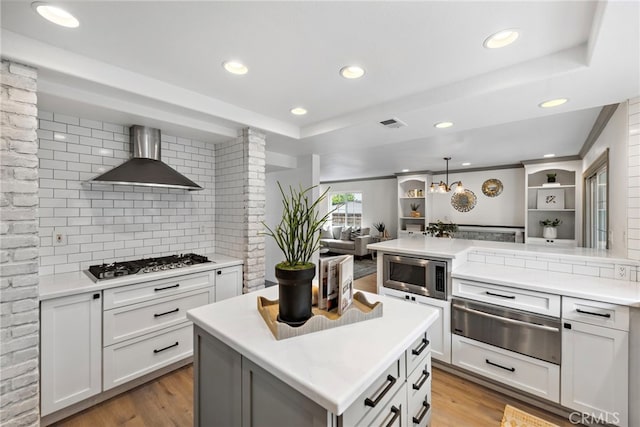 28166 Camellia Ct, Laguna Niguel, CA 92677 - kitchen with light wood finished floors, stainless steel appliances, tasteful backsplash, a warming drawer, and wall chimney exhaust hood