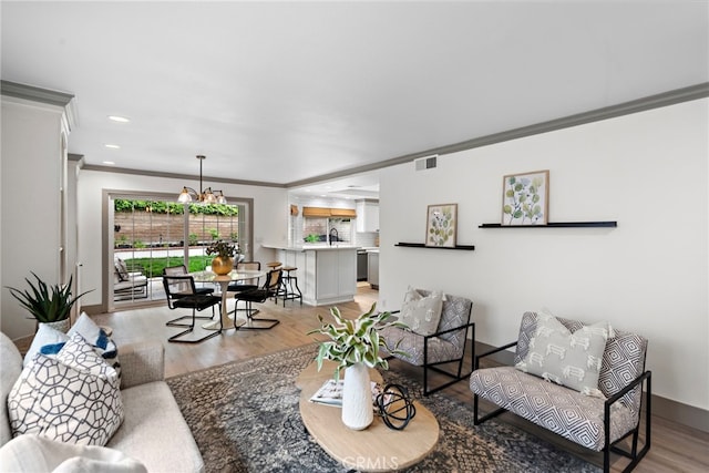 28166 Camellia Ct, Laguna Niguel, CA 92677 - living area featuring crown molding, light wood-style flooring, visible vents, a chandelier, and recessed lighting