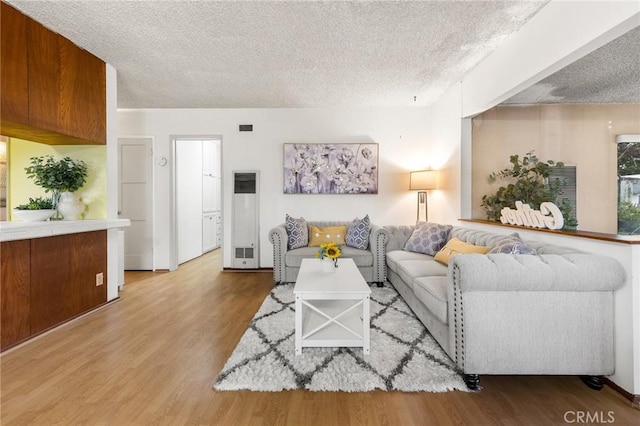 living area with wood finished floors and a textured ceiling