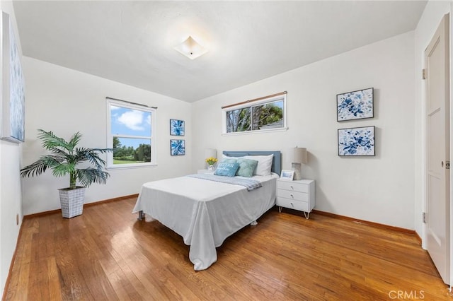 bedroom featuring baseboards and wood finished floors