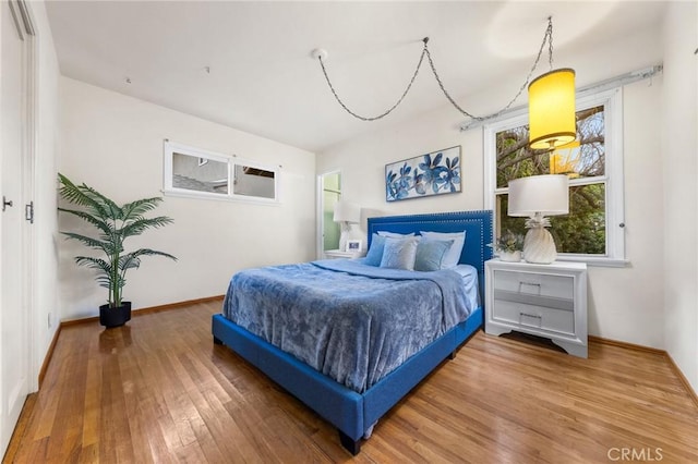 bedroom with baseboards and wood finished floors