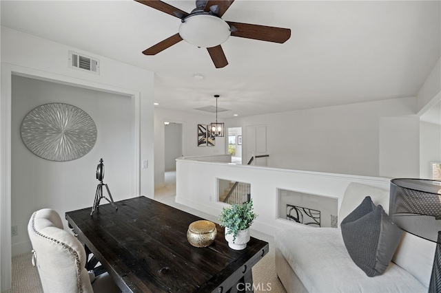 living area with visible vents and ceiling fan with notable chandelier