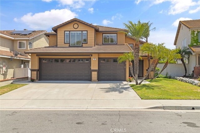 view of front of home with a front yard, a garage, driveway, stucco siding, and fence