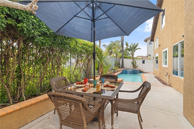 view of patio / terrace with a pool with connected hot tub, outdoor dining space, and a fenced backyard
