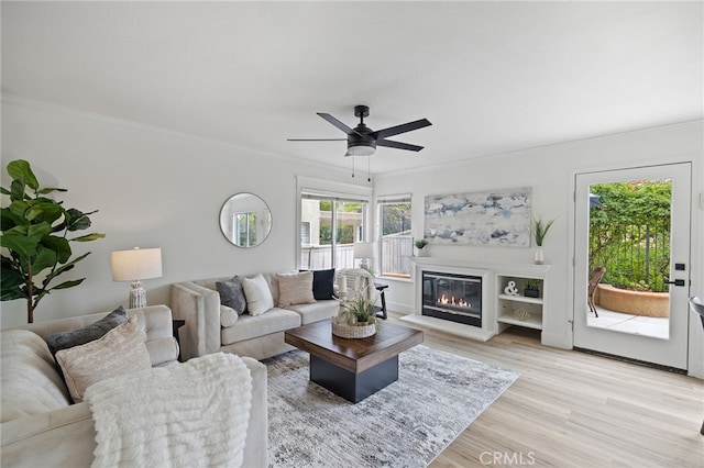 26 Apache Dr, Trabuco Canyon, CA 92679 - living room with crown molding, light wood-style floors, ceiling fan, and a glass covered fireplace
