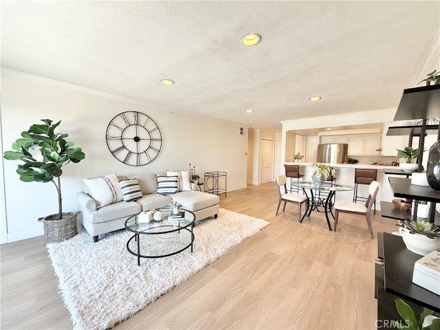 living room featuring crown molding, a textured ceiling, recessed lighting, light wood finished floors, and baseboards